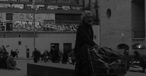Homeless man carrying a trolley