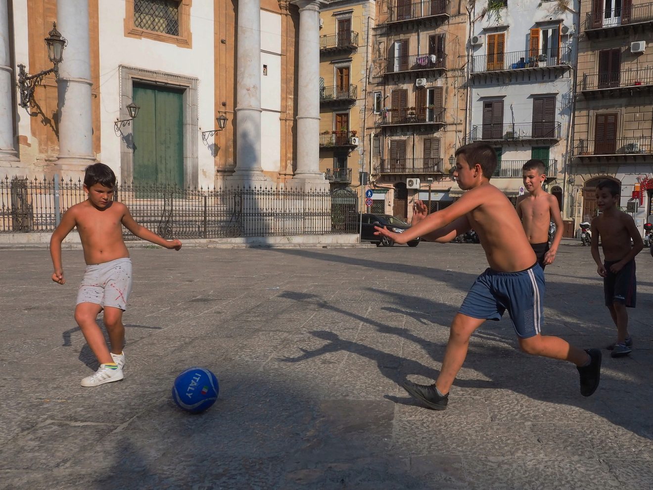 Children playing soccer on the street 1 Exibart Street