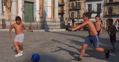 Children playing soccer on the street 1