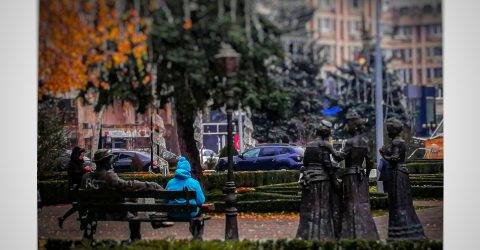Man sitting between statues