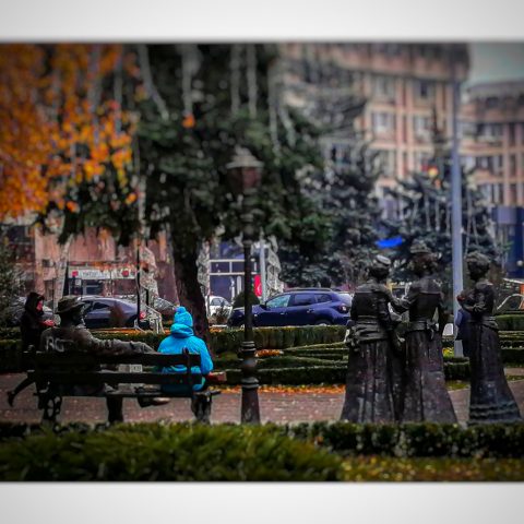 Man sitting between statues