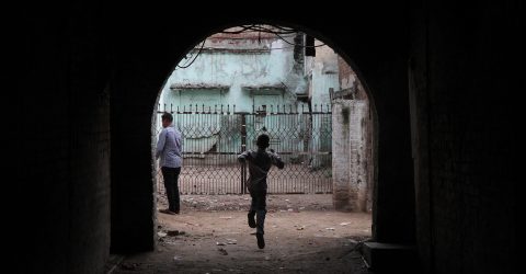 Boy runs through an alley inside the Walled City
