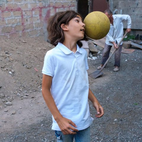 Street scene of a boy in a backyard in Etchmiadzin, Armenia