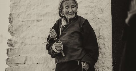 Old Tibetian woman holding a Mani
