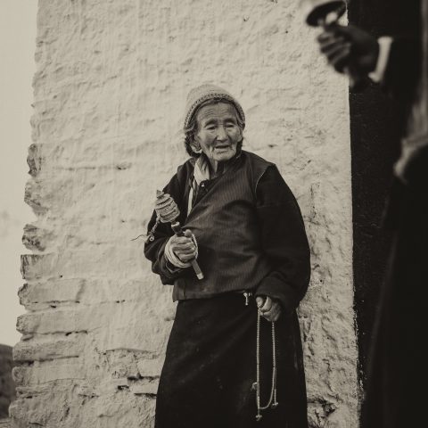 Old Tibetian woman holding a Mani